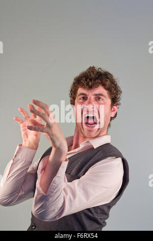 Man acting like an animal by growling snarling and clawing Stock Photo