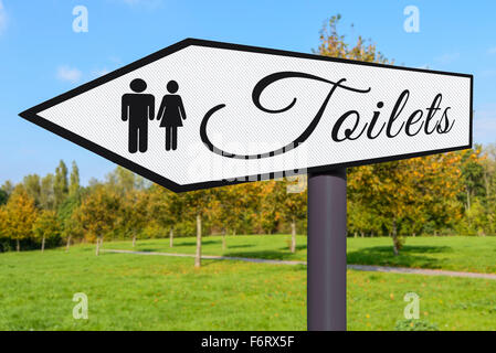 Toilet sign. Signpost pointing to the direction of public toilets. Stock Photo