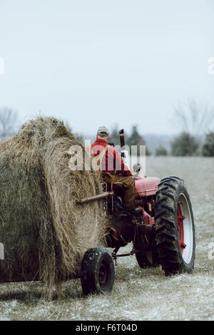 Caucasian farmer driving tractor in field Stock Photo
