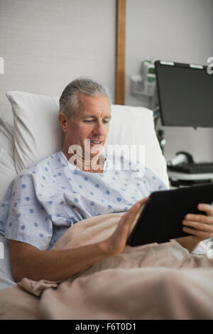Caucasian man using digital tablet in hospital room Stock Photo