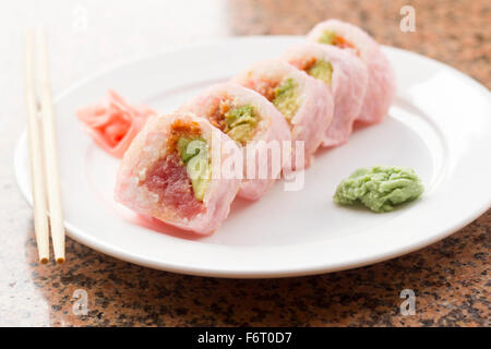 Pink sushi wrap tuna avocado roll with wasabi and pickled ginger Stock Photo