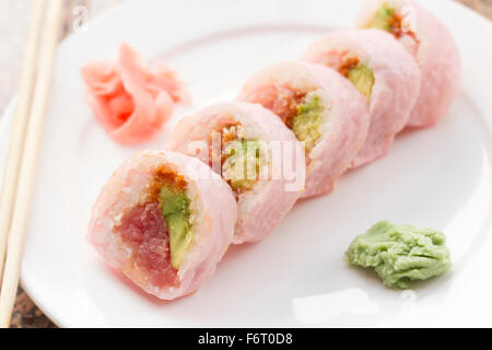 Pink sushi wrap tuna avocado roll with wasabi and pickled ginger Stock Photo