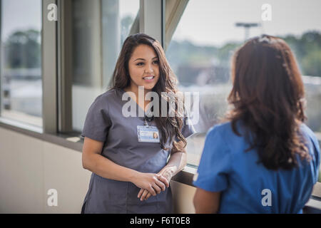 Nurses talking in hospital hallway Stock Photo