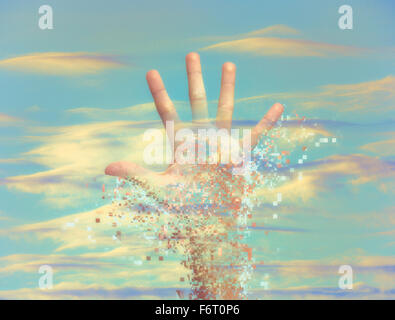 Pixelated hand dissolving in sky Stock Photo