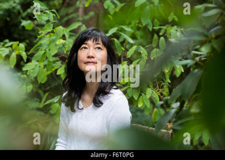 Japanese woman sitting in garden Stock Photo