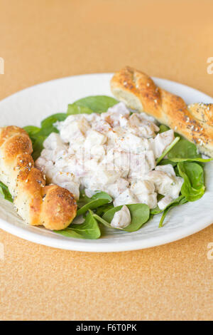 Potato salad on bed of spinach greens with bread stick twists Stock Photo