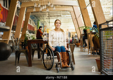 Paraplegic woman sitting in wheelchair in cafe Stock Photo