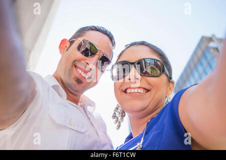 Low angle view of Hispanic couple wearing sunglasses Stock Photo