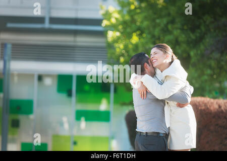 Hispanic couple hugging in city Stock Photo