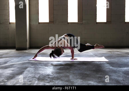 Caucasian woman practicing yoga in parking lot Stock Photo