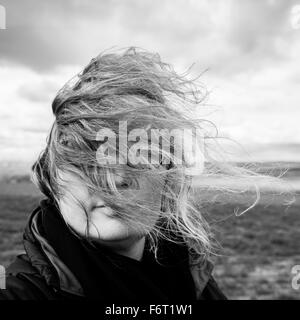 Caucasian woman with hair blowing in wind Stock Photo