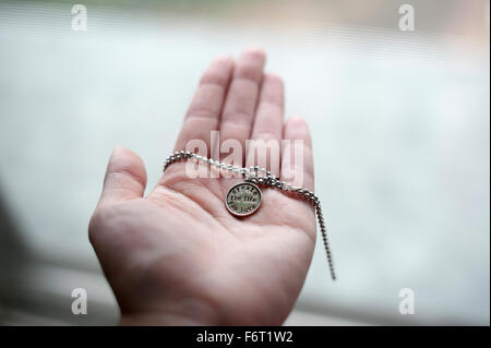 Hand of Caucasian woman holding necklace Stock Photo