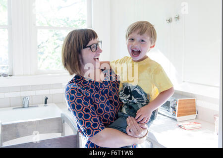 Mother holding son in kitchen Stock Photo