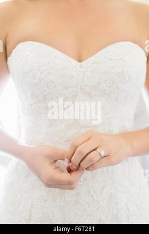 Close up of bride wearing wedding dress and engagement ring Stock Photo