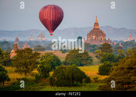 Hot air balloon flying over towers Stock Photo