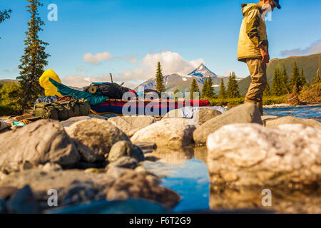Mari hiker standing on rocks in remote river Stock Photo