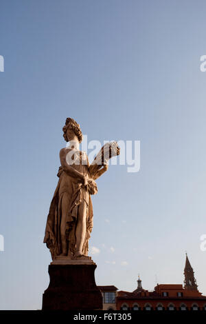 A statue representing Summer, in the sunset, on Ponte Santa Trinita, Florence, Italy Stock Photo