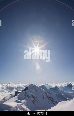 Sunshine over snowy mountaintops Stock Photo