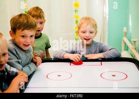 Caucasian boys playing air hockey Stock Photo