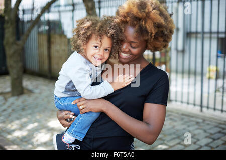Mother holding daughter outdoors Stock Photo