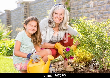 Caucasian grandmother and granddaughter gardening in backyard Stock Photo
