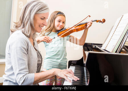 Caucasian grandmother and granddaughter playing music together Stock Photo