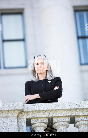 Caucasian businesswoman standing outside courthouse Stock Photo