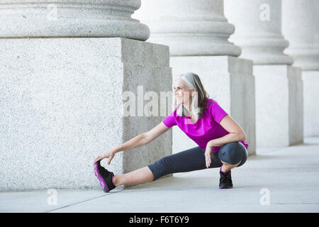 Caucasian woman stretching outside courthouse Stock Photo