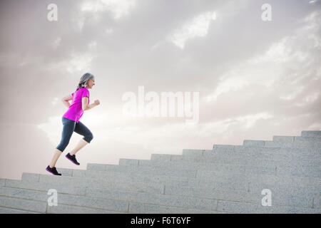 Caucasian woman jogging on steps Stock Photo