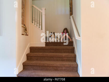 Caucasian girl and dog sitting on stairs Stock Photo