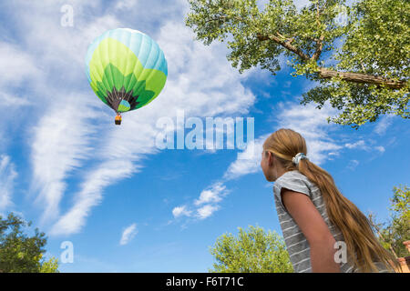 Caucasian girl watching hot air balloon Stock Photo