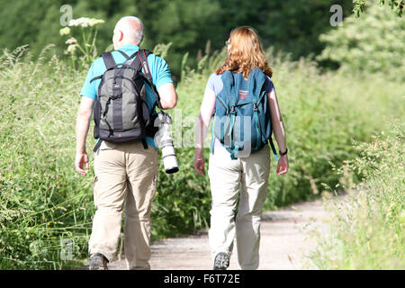 A couple mature hiking with a big camera on the Somerset Levels, near Ham Wall nature reserve Stock Photo