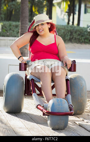 Paraplegic woman in wheelchair on walkway Stock Photo