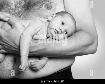 a sleeping baby lying on his father's arm Stock Photo