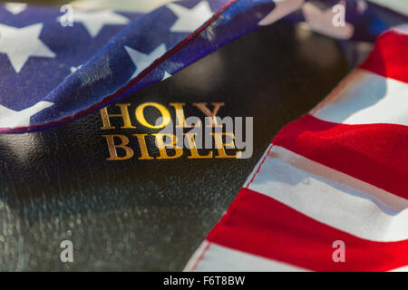 American flag draped over bible Stock Photo