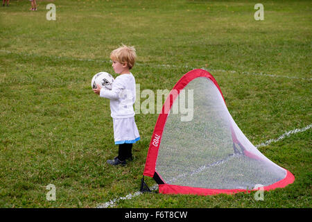 Caucasian boy playing soccer in field Stock Photo