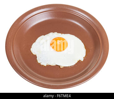 one fried egg on brown ceramic plate isolated on white background Stock Photo