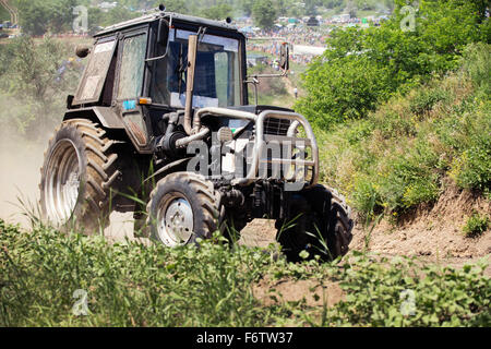 Farm tractor goes on road Stock Photo