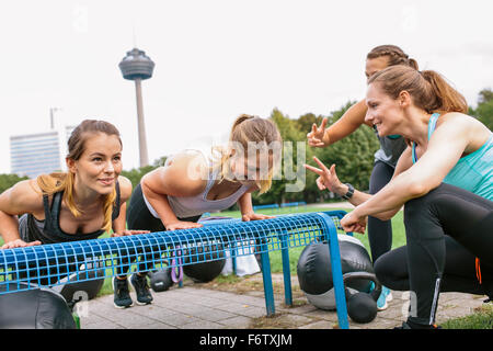 Four women having an outdoor boot camp workout