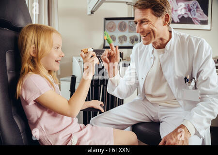 Doctor playing with little girl with in ENT practice, using finger puppets Stock Photo