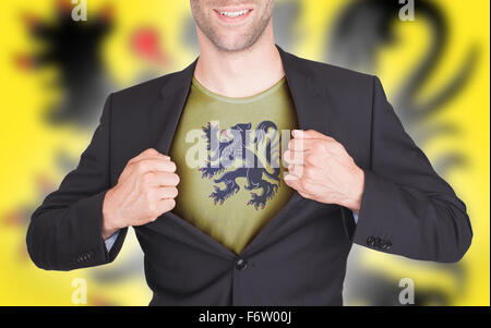 Businessman opening suit to reveal shirt with flag, Flanders Stock Photo