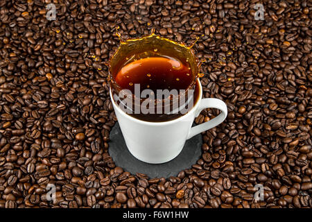 coffee cup splash on coffee beans Stock Photo