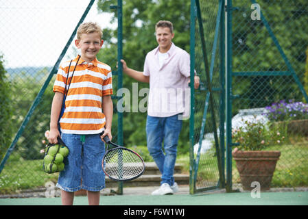 Father Dropping Son Off For Tennis Lesson Stock Photo