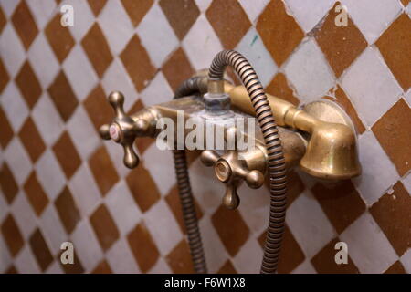 Vintage tap on a tiled wall Stock Photo