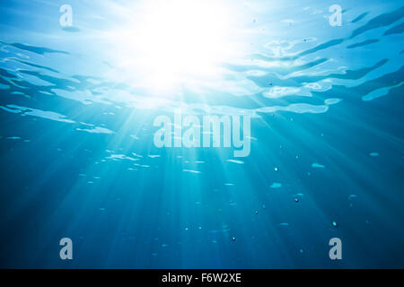 sun and sunbeams underwater shining through the surface Stock Photo