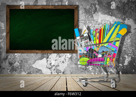 office / school supplies in shopping cart in front of classroom with blackboard Stock Photo