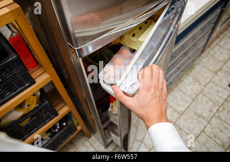 Hands of young man at home opening fridge for choosing food to eat. Self perspective point of view Stock Photo