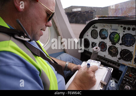Man with disability; who is wheelchair user; sitting in aircraft cockpit preparing to fly plane, Stock Photo