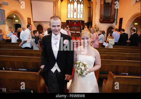 Bride and groom leaving church following marriage ceremony, Stock Photo