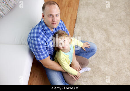 happy father and daughter sitting on sofa at home Stock Photo